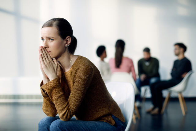Woman In Recovery Group Reflecting On Pride Vs. Ego During Addiction Treatment.
