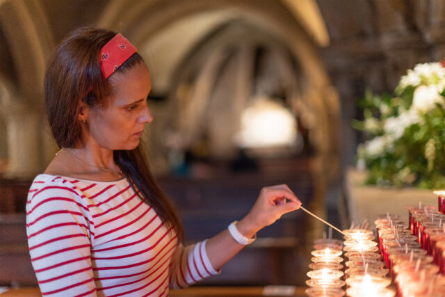 Thoughtful Hispanic Woman Lighting Candles In Chur 2025 02 15 23 38 43 Utc